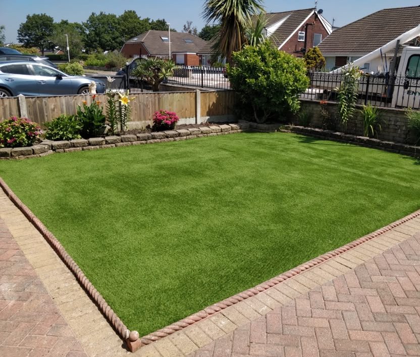 A front garden artificial lawn with brick edging