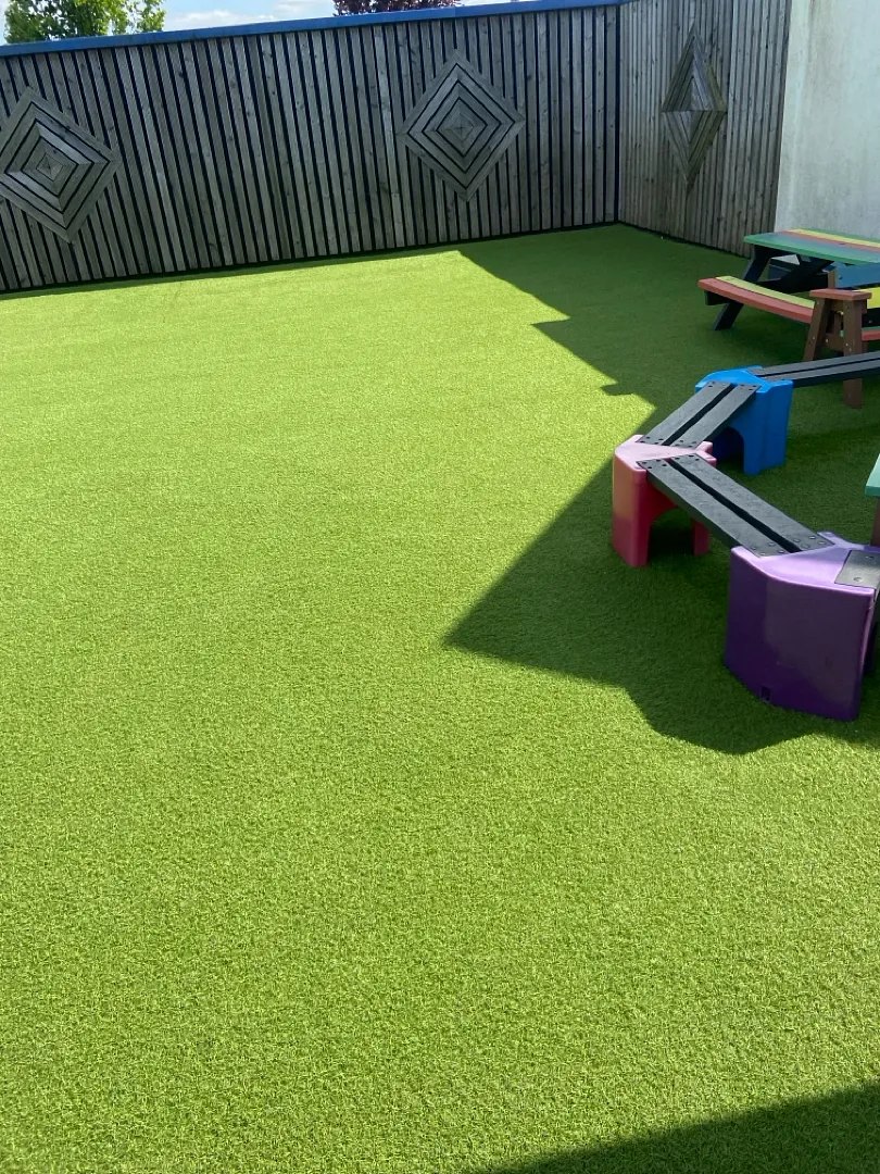 A school play area on artificial grass with seating