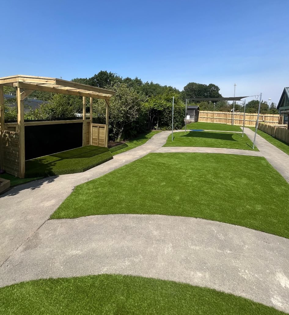 A play space with artificial grass and paths